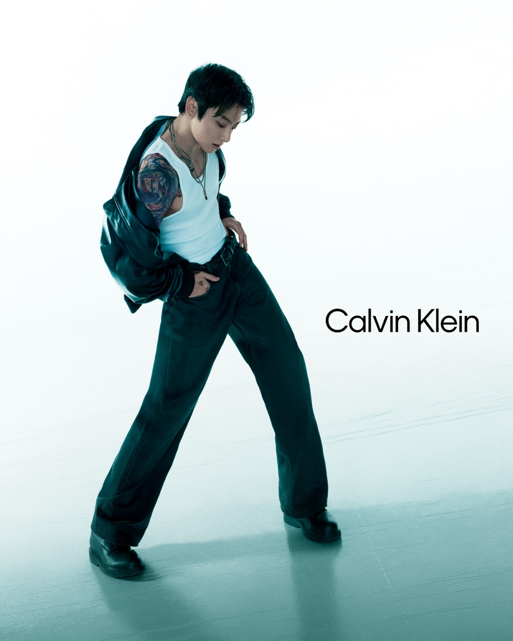 Jungkook in a dynamic pose wearing Calvin Klein leather jacket and denim