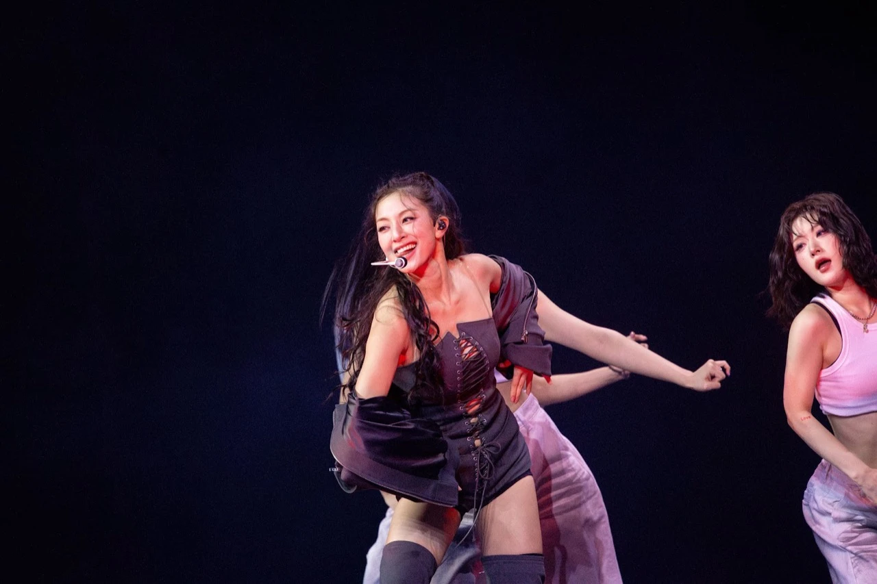 TWICE member performing under dramatic stage lighting at UBS Arena