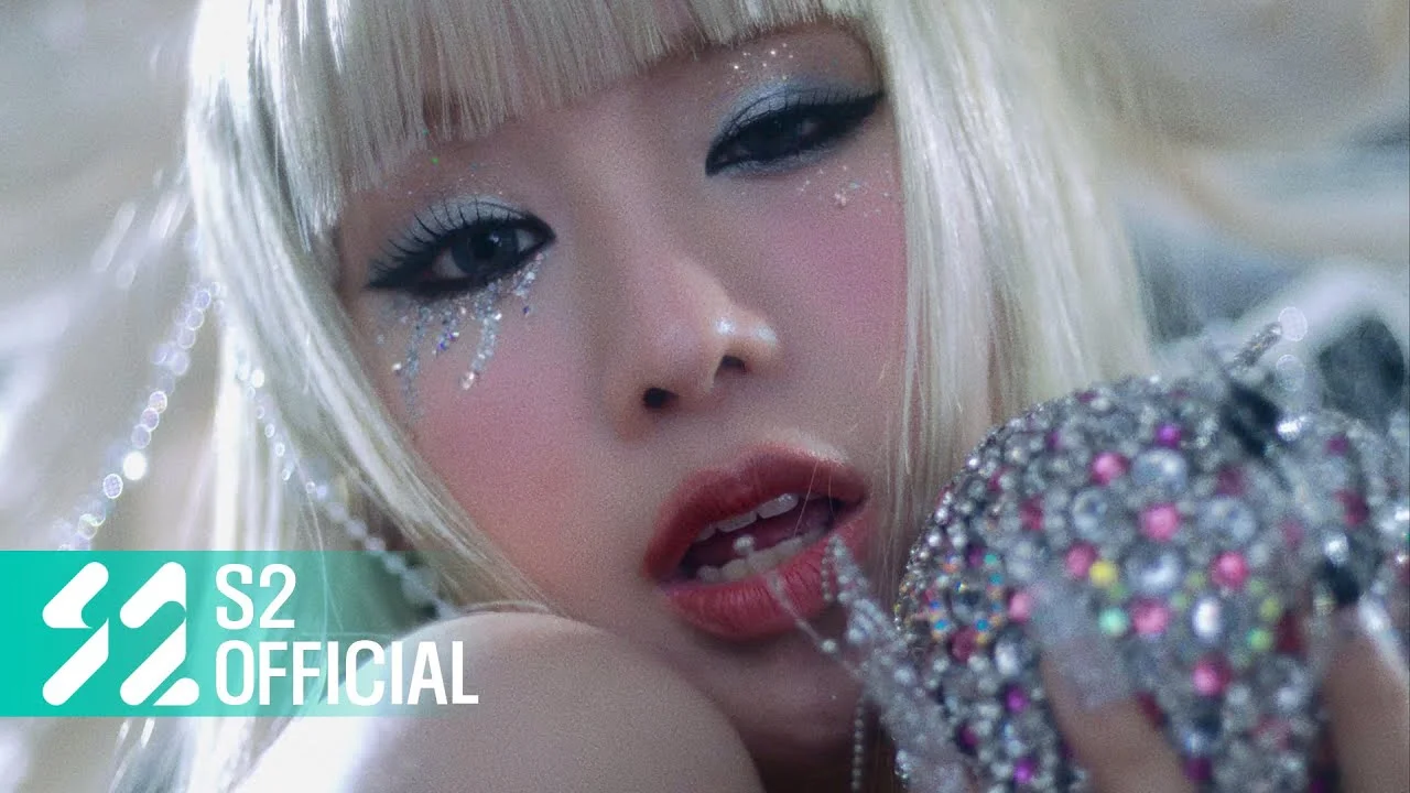 KISS OF LIFE member in Midas Touch promotional shoot, dramatic close-up with rhinestone styling