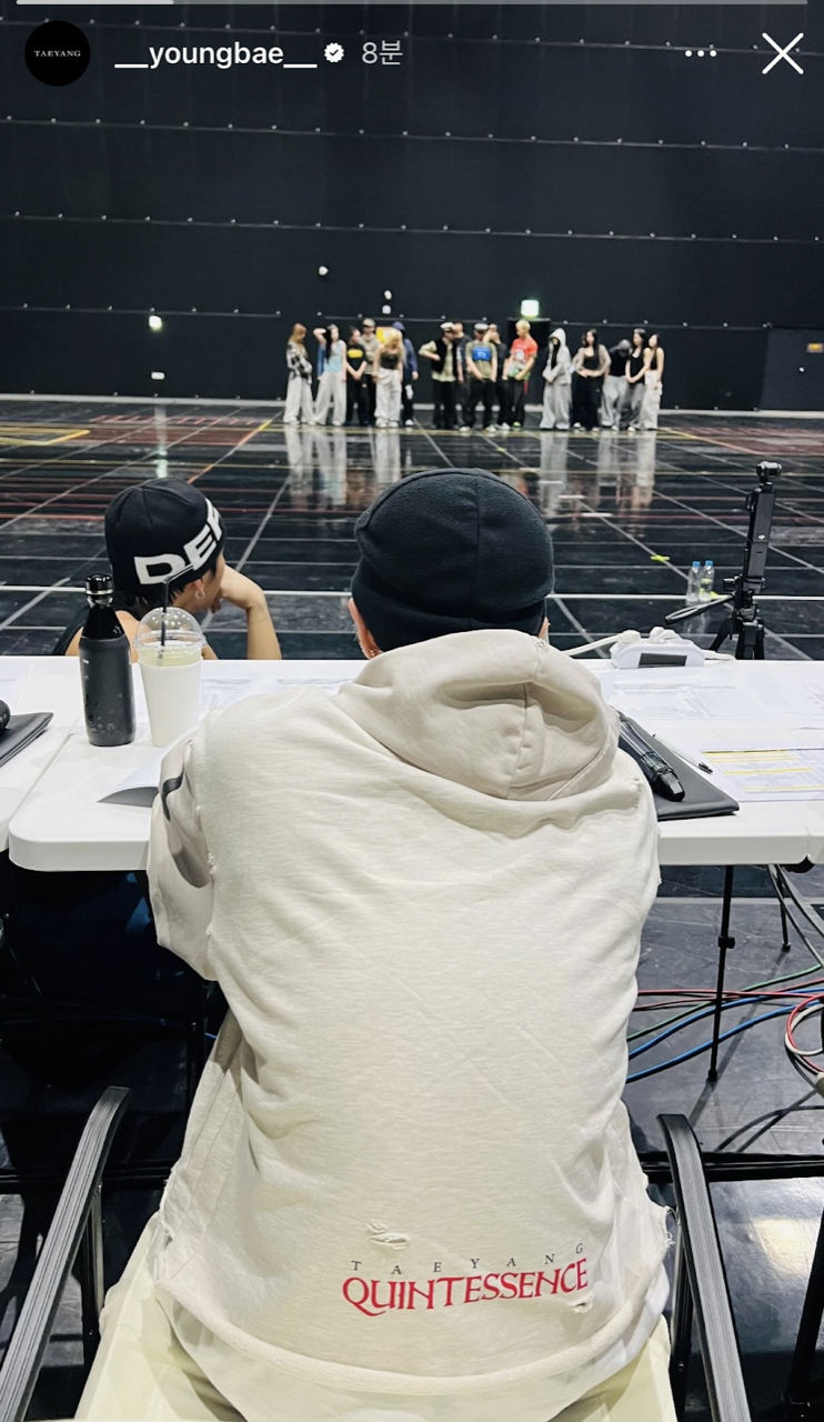 TAEYANG reviewing rehearsal for QUINTESSENCE 2026 with dancers in background