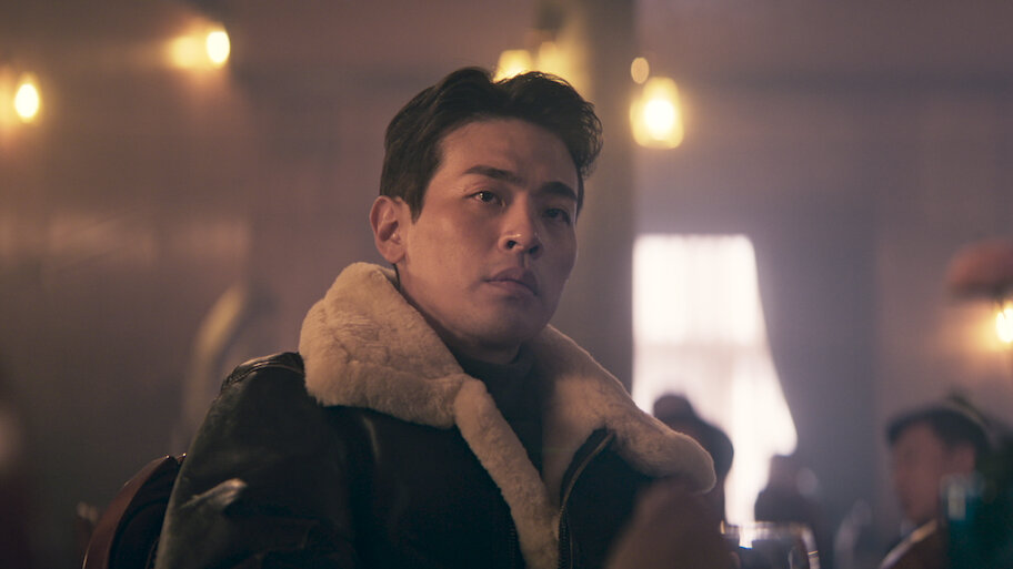 A tense scene from Humint showing a character seated in a dimly lit interior