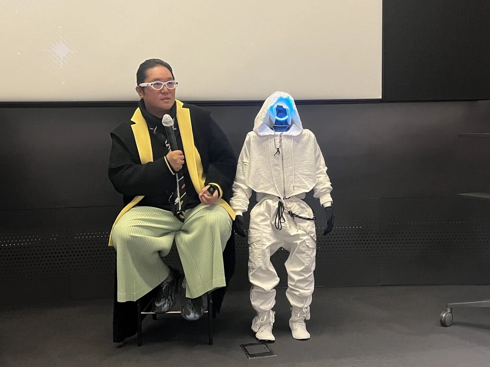Galaxy Corp chairman Choi Yong-ho seated beside a small humanoid robot during the White Whole launch event in Seoul