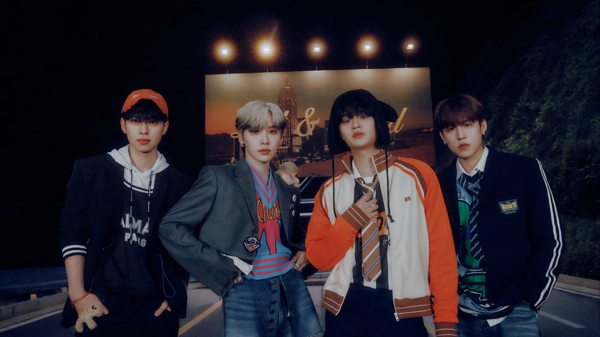 AB6IX pose together in a promotional group photo outdoors at night