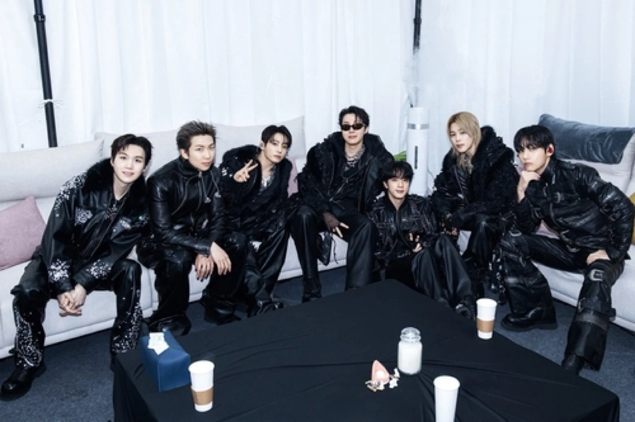 BTS posing together in black outfits in a backstage-style group photo