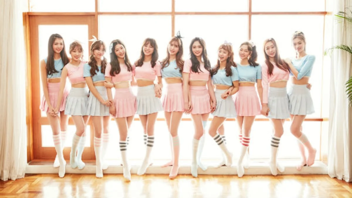 I.O.I members in matching pink outfits performing Pick Me choreography in a practice room