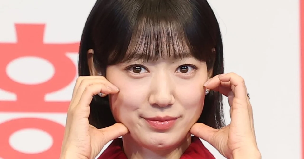 Park Shin Hye at a press event in a black outfit posing with both hands near her face