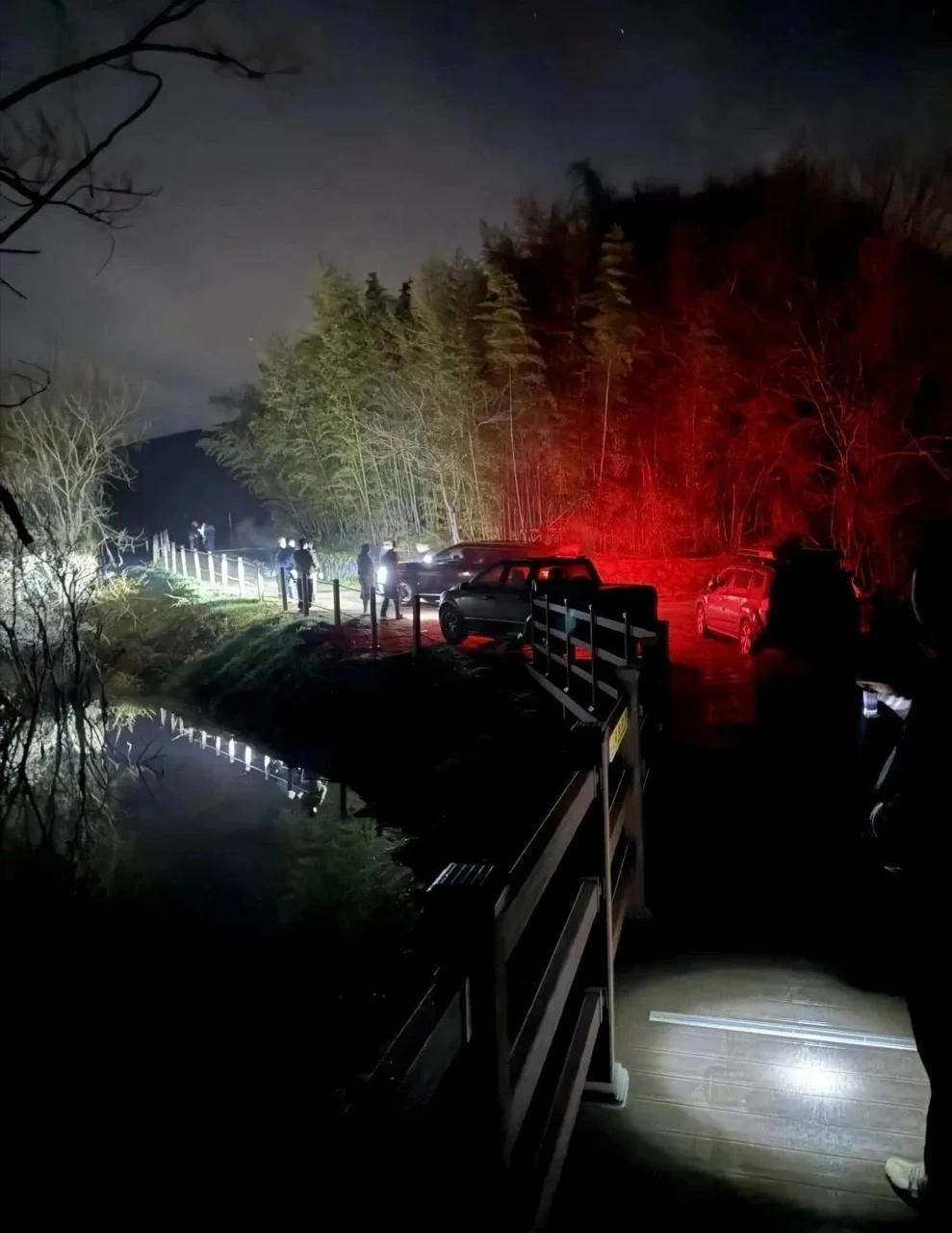 Nighttime crowd and vehicles gathered near the Salmokji reservoir filming location in Yesan