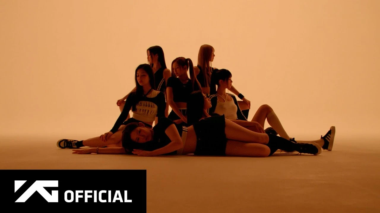BABYMONSTER members posed in a warm-toned formation from the official SHEESH performance video