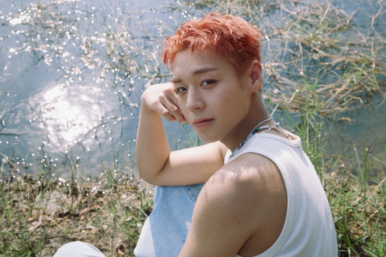 Park Ji Hoon in a sunlit promotional image beside the water during his RE:FLECT era