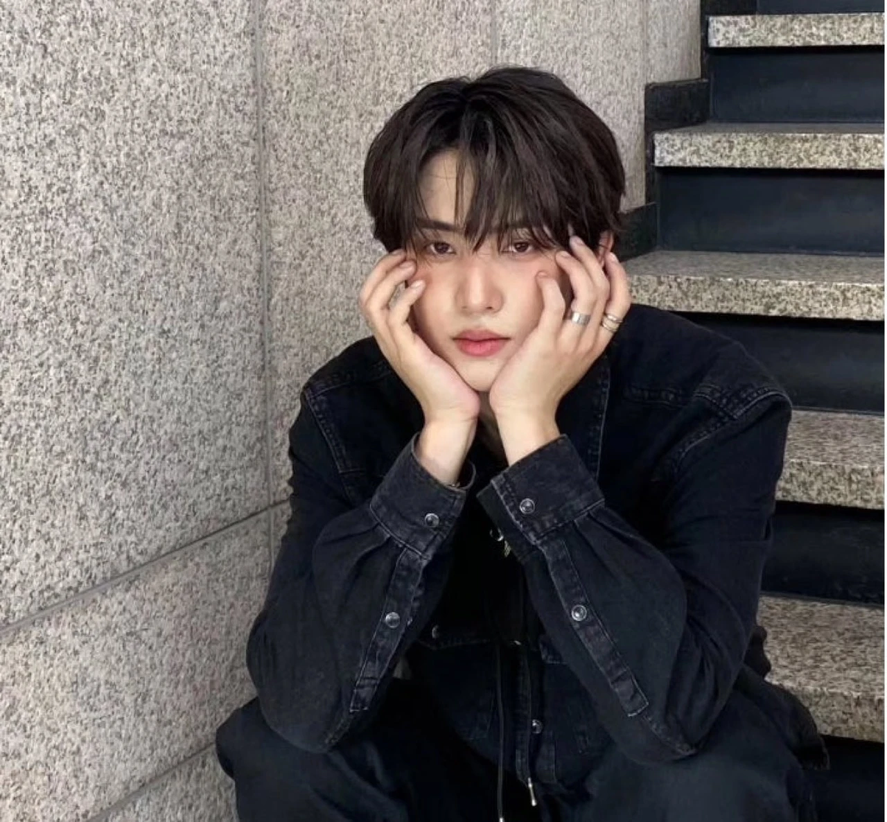 Doha in a dark outfit seated by a staircase in an Instagram photo