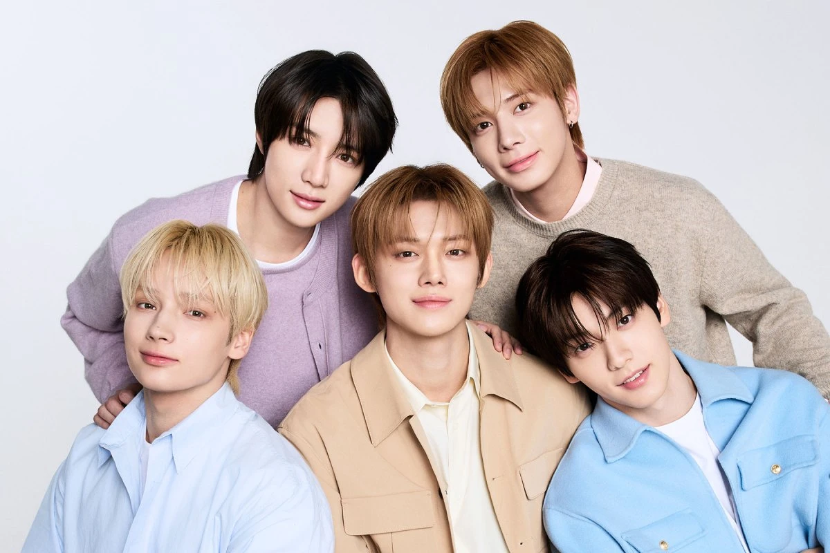 TOMORROW X TOGETHER in a studio group portrait wearing soft-toned outfits