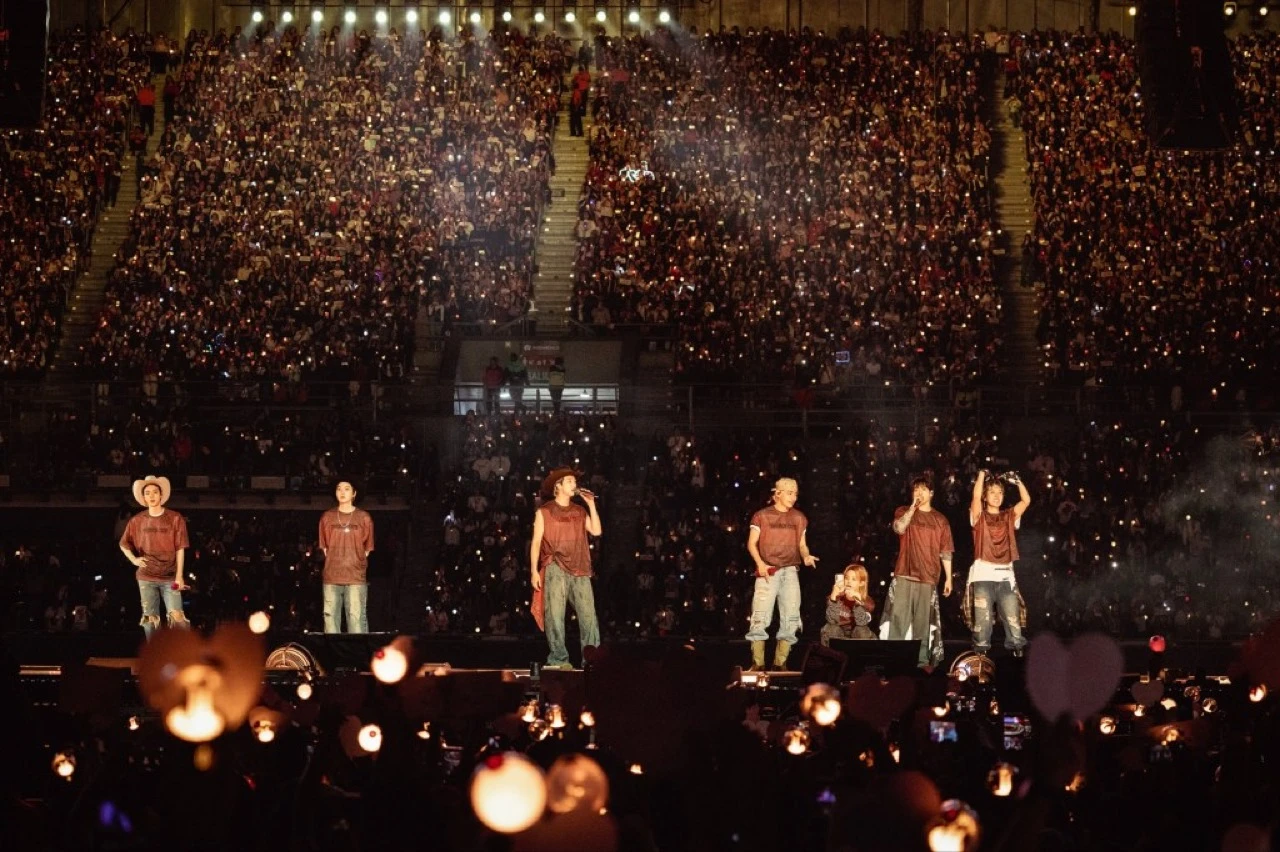 BTS performing in a packed stadium during the ARIRANG world tour