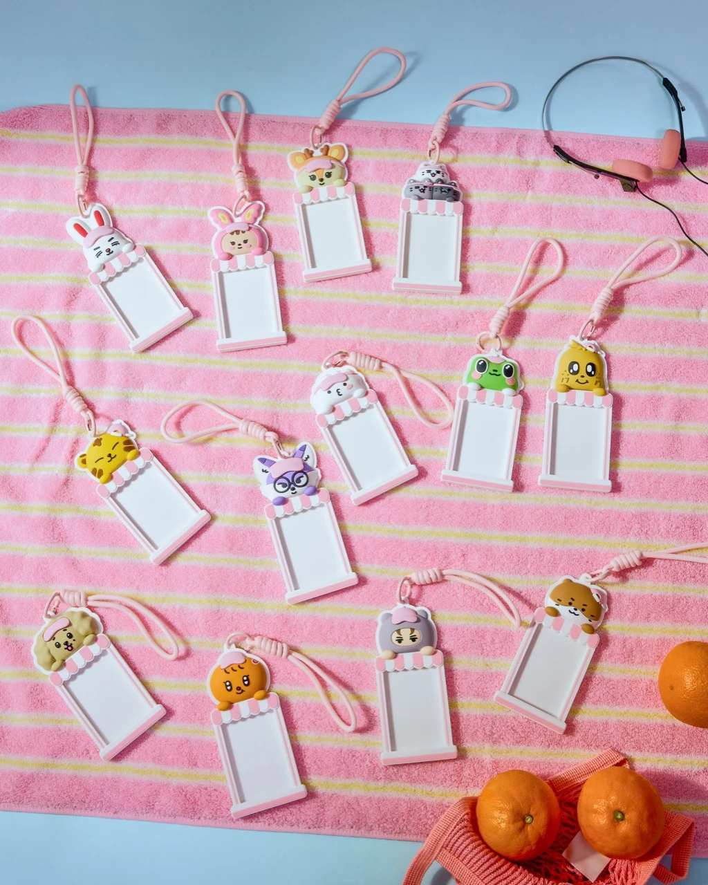 Official MINITEEN merch preview showing character card holders arranged on a pink-striped towel with summer props