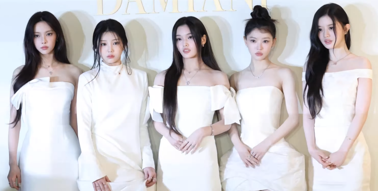 ILLIT posing together in coordinated white outfits at an official event